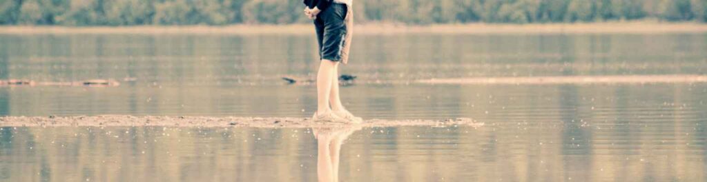 persona che si bagna i piedi nel lago, per simboleggiare la pianificazione del secondo trimestre